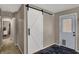 Hallway featuring a stylish barn door and an exterior door at 500 N Shellbark Rd, Muncie, IN 47304