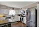 Bright kitchen featuring white cabinets, stainless steel appliances, and wood-look floors at 500 N Shellbark Rd, Muncie, IN 47304
