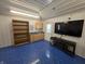 Finished garage featuring blue epoxy floors, TV, and storage cabinetry at 52 Spring Lake Ct, Trafalgar, IN 46181
