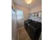 Functional laundry room with modern appliances, shelving, and natural light from the window at 52 Spring Lake Ct, Trafalgar, IN 46181