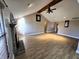 Open living room with vaulted ceilings, beam, brick fireplace, and wood-look flooring at 52 Spring Lake Ct, Trafalgar, IN 46181