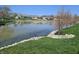 Picturesque view of a pond with a grassy shoreline and mature trees at 52 Spring Lake Ct, Trafalgar, IN 46181