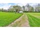 A lush backyard featuring mature trees, a gravel driveway, and a white outbuilding, blending nature and functionality at 5301 Old Smith Valley Rd, Greenwood, IN 46143