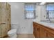 Bathroom featuring a wooden vanity, white toilet and tiled floors at 5301 Old Smith Valley Rd, Greenwood, IN 46143