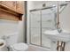 Functional bathroom featuring a shower with sliding glass doors, a pedestal sink, and a classic toilet at 5301 Old Smith Valley Rd, Greenwood, IN 46143