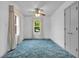 Bright bedroom with plush blue carpet, neutral walls, a ceiling fan, and large windows letting in natural light at 5301 Old Smith Valley Rd, Greenwood, IN 46143