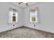 Comfortable bedroom with neutral walls, plush carpet, ceiling fan, and windows with views of the outdoors at 5301 Old Smith Valley Rd, Greenwood, IN 46143
