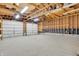 Unfinished garage with wooden beams, two car garage door, shelving, and concrete floor at 5301 Old Smith Valley Rd, Greenwood, IN 46143