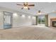Large carpeted living room with fireplace, ceiling fans, and sliding door access to the deck at 5301 Old Smith Valley Rd, Greenwood, IN 46143