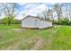 Side view of a white vinyl outbuilding with a gravel drive and grass; offering functional space at 5301 Old Smith Valley Rd, Greenwood, IN 46143