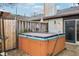 Private backyard with a wood-paneled hot tub, patio, and fenced perimeter at 5431 Carlton Ct, Indianapolis, IN 46224