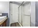 Bathroom with glass shower door, wood-look floor, and blue subway tile backsplash at 5431 Carlton Ct, Indianapolis, IN 46224