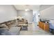 A living room featuring a comfortable gray sofa, wood floors, and an entrance to the hallway at 5431 Carlton Ct, Indianapolis, IN 46224