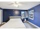 Spacious bedroom with wood-look floors, blue walls, decor accents, and bright window views at 5431 Carlton Ct, Indianapolis, IN 46224