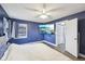 Cozy bedroom with a mounted television, window views, and blue-painted walls at 5431 Carlton Ct, Indianapolis, IN 46224