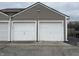 View of attached garages with white doors, offering convenient parking and storage, enhancing the functionality of the home at 6005 Wingedfoot Ct, Indianapolis, IN 46254