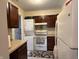 Efficient kitchen with dark cabinets, appliances, and space-saving washer and dryer for convenience, maximizing functionality at 6005 Wingedfoot Ct, Indianapolis, IN 46254