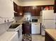 Well-organized kitchen with dark cabinetry, essential appliances, and clean tile floors, offering efficiency and style at 6005 Wingedfoot Ct, Indianapolis, IN 46254