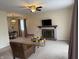 Inviting living room featuring a cozy fireplace, plush carpeting, and a stylish ceiling fan, perfect for relaxation and entertainment at 6005 Wingedfoot Ct, Indianapolis, IN 46254