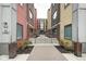 Exterior view of colorful townhomes with brick and siding, plus a brick walkway and landscaping at 622 E 10Th St # 303, Indianapolis, IN 46202