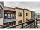 This home exterior has yellow siding, dark trim, and small balcony with seating at 622 E 10Th St # 303, Indianapolis, IN 46202