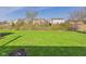 Picture of a spacious backyard with lush lawn, bordered by trees, and a fire pit at 6233 Boulder Dr, Anderson, IN 46013