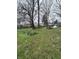 View of a grassy backyard with mature trees and natural landscaping features at 630 Congress Ave, Indianapolis, IN 46208