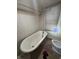 Bathroom with bathtub, toilet, tile wall, window and shower head at 630 Congress Ave, Indianapolis, IN 46208