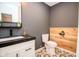 Modern bathroom with wood accent wall, vanity with black countertop and decorative tile floor at 632 Ridgeview Ln, Columbus, IN 47201