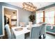 Elegant dining room with a modern light fixture, white table set for six, and luxury vinyl flooring at 632 Ridgeview Ln, Columbus, IN 47201