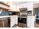 Kitchen featuring stainless steel appliances, floating shelves, white cabinets, and subway tile backsplash at 632 Ridgeview Ln, Columbus, IN 47201