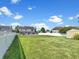 Spacious backyard with in-ground pool, white picket fence, and large lawn area at 7034 Endicott Way, Indianapolis, IN 46259