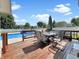 Wooden deck provides ample seating space, with an umbrella and views of a large swimming pool at 7034 Endicott Way, Indianapolis, IN 46259