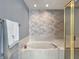 Bright bathroom features a luxurious soaking tub with a stylish brick accent wall at 7034 Endicott Way, Indianapolis, IN 46259