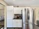 This kitchen features stainless steel refrigerator with white cabinets and black countertops at 7034 Endicott Way, Indianapolis, IN 46259