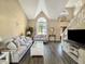 Bright living room with vaulted ceiling, large windows, and comfortable seating at 7034 Endicott Way, Indianapolis, IN 46259