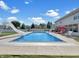In-ground swimming pool in backyard with slide, cover, and nearby covered patio seating at 7034 Endicott Way, Indianapolis, IN 46259