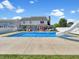 Large in-ground backyard pool with slide, lounge seating, and a well maintained lawn at 7034 Endicott Way, Indianapolis, IN 46259