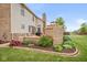 A beautifully landscaped yard featuring a custom fireplace and retaining wall surrounded by vibrant plantings at 732 Trillium St, Lebanon, IN 46052