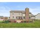 A backyard view with a charming outdoor fireplace, patio, and well-maintained landscaping at 732 Trillium St, Lebanon, IN 46052