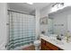 Bright bathroom with a shower featuring striped curtain, white toilet and classic wood vanity at 732 Trillium St, Lebanon, IN 46052