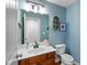 Bathroom features wood cabinets, large mirror, and updated lighting at 732 Trillium St, Lebanon, IN 46052