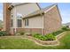 Manicured backyard featuring a retaining wall with garden beds, complemented by brick and vinyl siding at 732 Trillium St, Lebanon, IN 46052