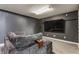 Cozy basement area with a large, comfortable gray couch and mounted TV at 8415 Anchorage Ct, Indianapolis, IN 46236