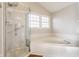 Bright bathroom featuring a shower, and a tiled soaking tub next to the window at 8415 Anchorage Ct, Indianapolis, IN 46236