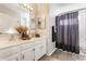 Bright bathroom featuring a double vanity with warm accents and a gray shower curtain at 8415 Anchorage Ct, Indianapolis, IN 46236