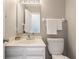 Cozy bathroom with white vanity, sink, and toilet, plus decorative towels and a large mirror at 8415 Anchorage Ct, Indianapolis, IN 46236
