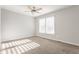Well-lit bedroom with carpet flooring, a ceiling fan, and a large window for natural light at 8415 Anchorage Ct, Indianapolis, IN 46236