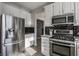 Well-equipped kitchen with stainless steel appliances, white cabinets, and sleek black backsplash at 8415 Anchorage Ct, Indianapolis, IN 46236