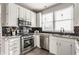 Charming kitchen features white cabinets, stainless steel appliances, and dark subway tile backsplash at 8415 Anchorage Ct, Indianapolis, IN 46236